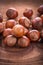Small stack of hazelnuts on vintage wooden board