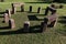 Small stonehenge built from rectangular blockstones, placed on decorative lawn in park, sunbathing in late afternoon sunshine.