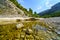 Small stream in the mountain valley with large eroded stones.