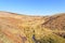 Small stream runs between gentle hills in Derbyshire on a spring morning