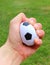 Small stress ball in hand on grass background