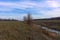 Small swampy river in the field. Wilted grasses on the banks of the river. Evening landscape