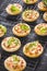 Small tarte flambee or mini pizza with onion, bacon and arugula