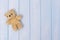 Small teddy bear on blue pastel wooden background, top view