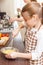 Small teenage girl whisks eggs in the mixing bowl