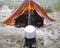 Small tent at a beach with shoes and cooking pot