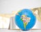 small terrestrial globe south america and africa side isolated on shades of white and gold