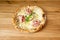 Small thin-crust baked pizza with goat cheese, mortadella mortadella slices, basil leaves, pistachio pieces