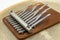 Small thumb piano with silver tines, brown wood