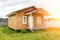 Small tiny wooden frame house with sundeck and white windows and door as a country residence in sunny summer day