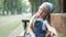 Small tired child girl sitting on a bench with closed eyes resting in summer park.