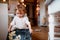 A small toddler girl making cakes on the floor in the kitchen at home.