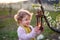 Small toddler girl standing outdoors in orchard in spring, holding lantern.