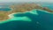 Small torpic island with a white sandy beach, top view.