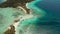 Small torpic island with a white sandy beach, top view.