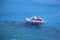 Small tourist boat at Preveli lagoon in crystal clear waters of Mediterranean sea in Crete. Greece.