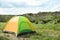 Small tourist tent in wilderness. Camping equipment