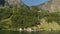 Small Town Under Huge Waterfall in the Fjords of Norway