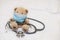 small toy bear with phonendoscope on bed. Toy in a protective medical mask in children's games. Coronovirus, quarantine,