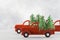 Small toy cars carring christmas tree on blue background . Sesonal holidays, greeting card, christmas mood concept