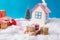 Small toy santa claus white comfort cozy warm house with smoke concept deliver red brown giftboxes on wooden sledges
