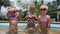 small triplets sisters playing in the pool in swimsuits