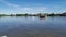 Small tug boat pulls a barge on a Thai river