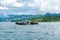 Small tugboat carries pontoon to ship that anchoring in Padang bay