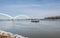 Small tugboat or towboat sail on the Danube river with clear blue sky above and the bridge in the background.