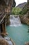 Small turquoise waterfall in a river