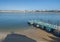 Small turquoise wooden pier at Praia das Furnas sand beach with view over the Mira river to Vila Nova de Milfontes