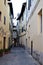 Small typical cross between buildings with arched door in the center of Pistoia.