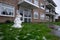 Small ugly snowman melting in the garden of a small residental building in Cambridge. First snow of the 2020 year and children are