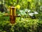 Small unopened bottle with the contents on the green natural background. A small bottle of agarwood oil at natural green backgroun