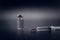 Small vaccine bottle phial and a medical syringe injection with a vaccine drop on its needle, isolated on black background