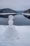 Small version of a snowman. Winter landscape at Soesetalsperre in Harz Mountains National Park, Germany. Moody snow scenery in