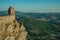 Small watchtower and stone wall over cliff with mountainous landscape