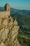 Small watchtower and stone wall over cliff with mountainous landscape