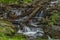 Small waterfall on Divoky creek near Kouty nad Desnou village in summer day