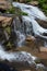 Small waterfall flowing down a rockface in the forest