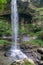 Small waterfall hitting and splash on the surface of hard rocks