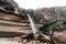 small waterfall with little water pushed by the force of the wind coming down from the large rocks with curious shapes