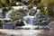 Small Waterfall in park with beautifull smooth water. Little waterfall in mountain forest with silky foaming water.