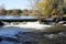 Small waterfall in river on sunny day