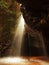 Small waterfall on small mountain stream, mossy sandstone block and water is jumping down into small pool. Water streams with