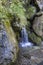 Small waterfall between stones covered with moos