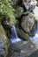 Small waterfall between stones covered with moos