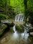 A small waterfall surrounded by rocks and vegetation