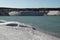 Small waves on blue water and a sandy beach. Pond on a sand quarry.