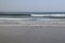 Small waves breaking on the sand of Fonte da Telha Beach, Portugal.